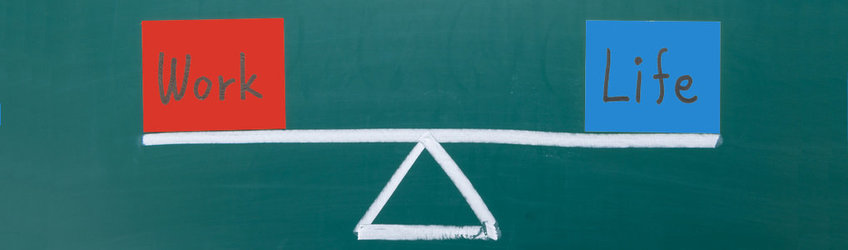 Clothes rack with schematic representation of a seesaw with the building blocks “Work” on the left and “Life” on the right.