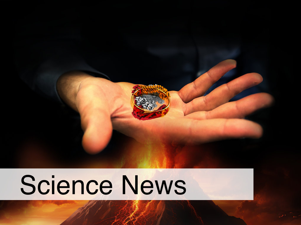 A ring showing a protein structure lies in the palm of a hand. The hand hovers above an erupting volcano. The background is black.